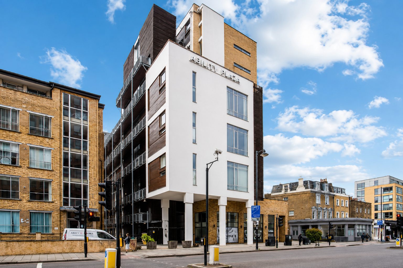 Ability Plaza's white-panelled corner on Kingsland Road, with timber-lined balconies along the adjoining elevation
