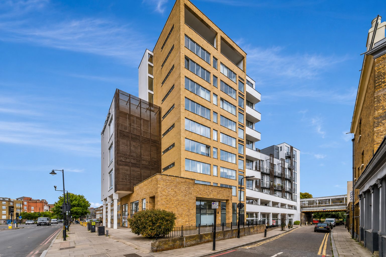 A brick residential tower in Ability Plaza's wider Kingsland Road development, with tall windows and projecting balconies