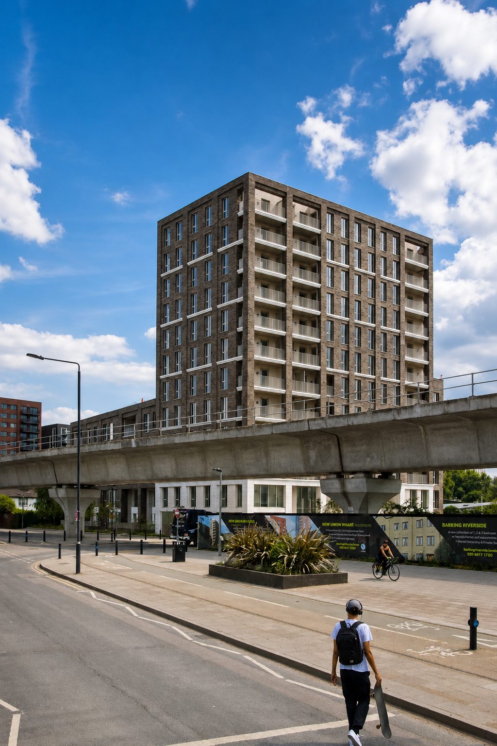 The Refinery's brick-clad tower and its balconies rising behind the DLR viaduct, Silvertown