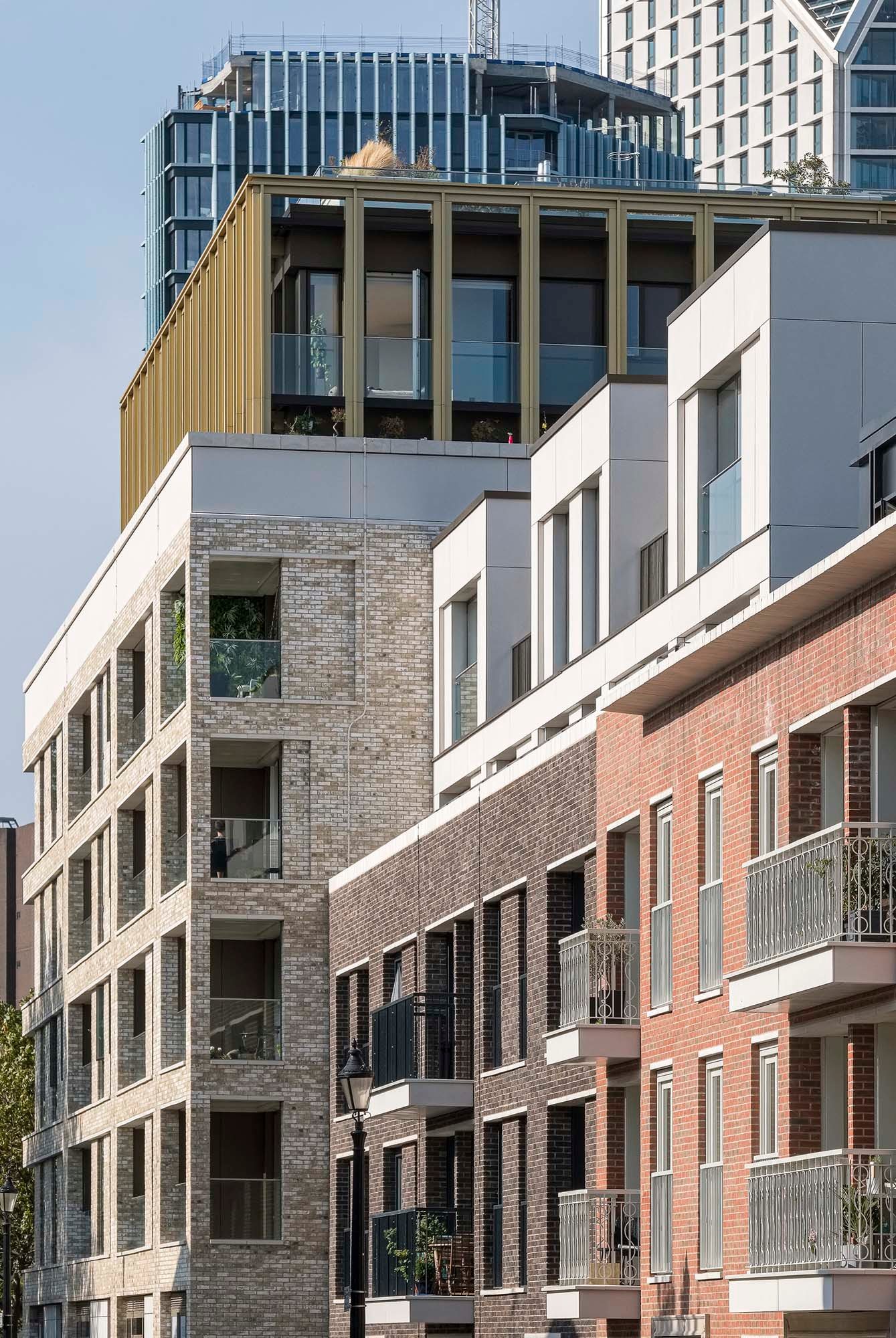 Design visualisation of Trilogy's brick corner at dusk, its ground-floor units lit from within and the Shard beyond
